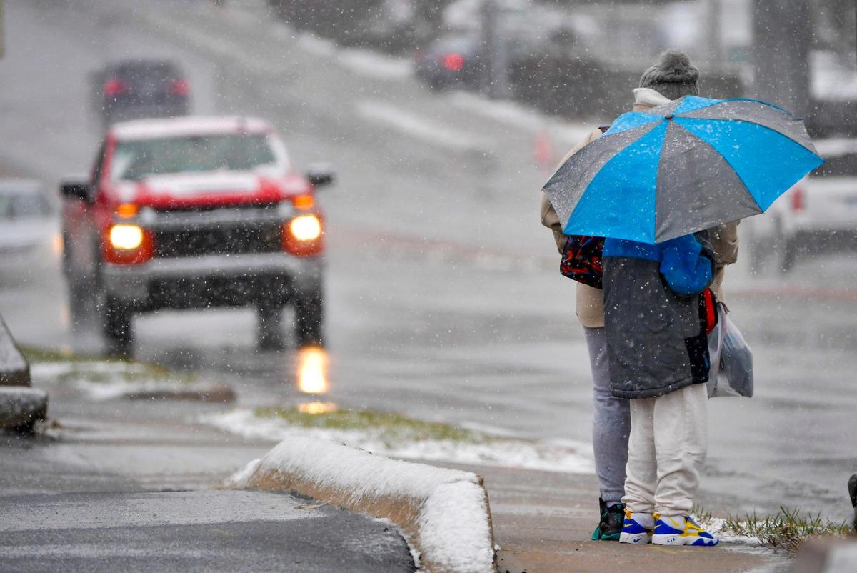 People waited in the rain and snow at a bus stop near W. 87th and Grant Streets in the Elmhurst neighborhood on Monday, Jan. 8, 2024, in Overland Park.