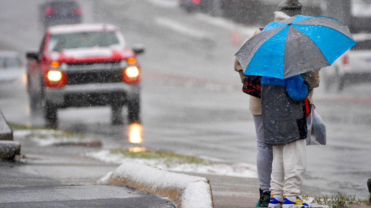 People waited in the rain and snow at a bus stop near W. 87th and Grant Streets in the Elmhurst neighborhood on Monday, Jan. 8, 2024, in Overland Park. A winter storm warning was in effect for the Kansas City metro for Monday and Tuesday bringing rain, snow and wind to the area.