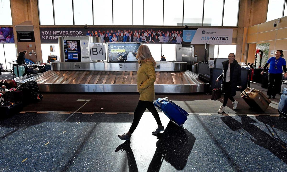 With a smile on her face after finding her luggage at the Southwest Airline baggage claim, Austen Fugate, right, headed out the B Terminal door with friend Bridgett Schmitz. Fugate said that her luggage was flown from Nahsville to Kansas City without her after her flight was canceled. She rebooked and made it to Kansas City Tuesday on an American Airlines flight.