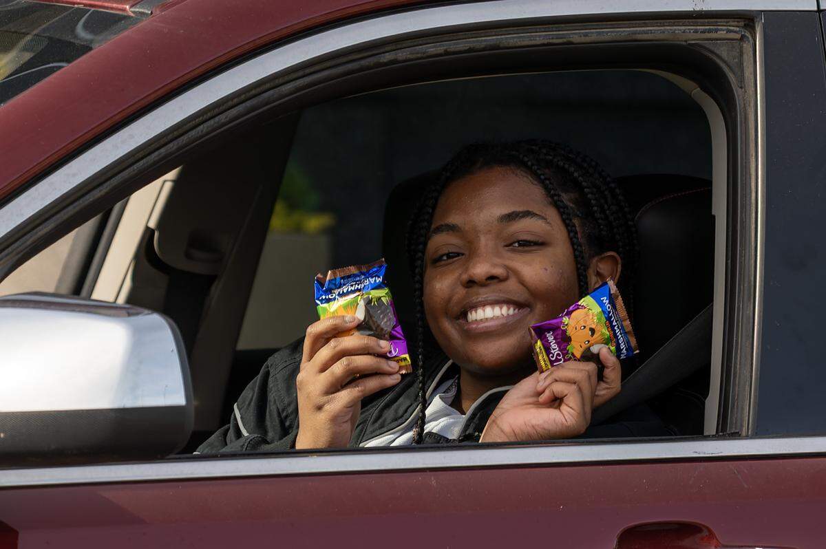 Liberty Calhoun shows Halloween candy she received from Russell Stover's annual giveaway while driving through the company's headquarters on Friday, Oct. 31, 2025, in Kansas City.