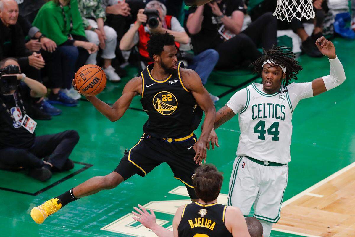 Golden State Warriors forward Andrew Wiggins (22) passes the ball against Boston Celtics center Robert Williams III (44) during the fourth quarter of Game 4 of basketball’s NBA Finals, Friday, June 10, 2022, in Boston. (AP Photo/Michael Dwyer)