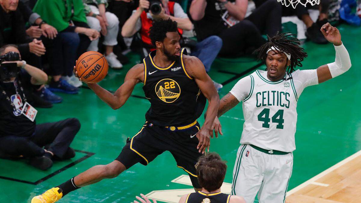 Golden State Warriors forward Andrew Wiggins (22) passes the ball against Boston Celtics center Robert Williams III (44) during the fourth quarter of Game 4 of basketball’s NBA Finals, Friday, June 10, 2022, in Boston. (AP Photo/Michael Dwyer)