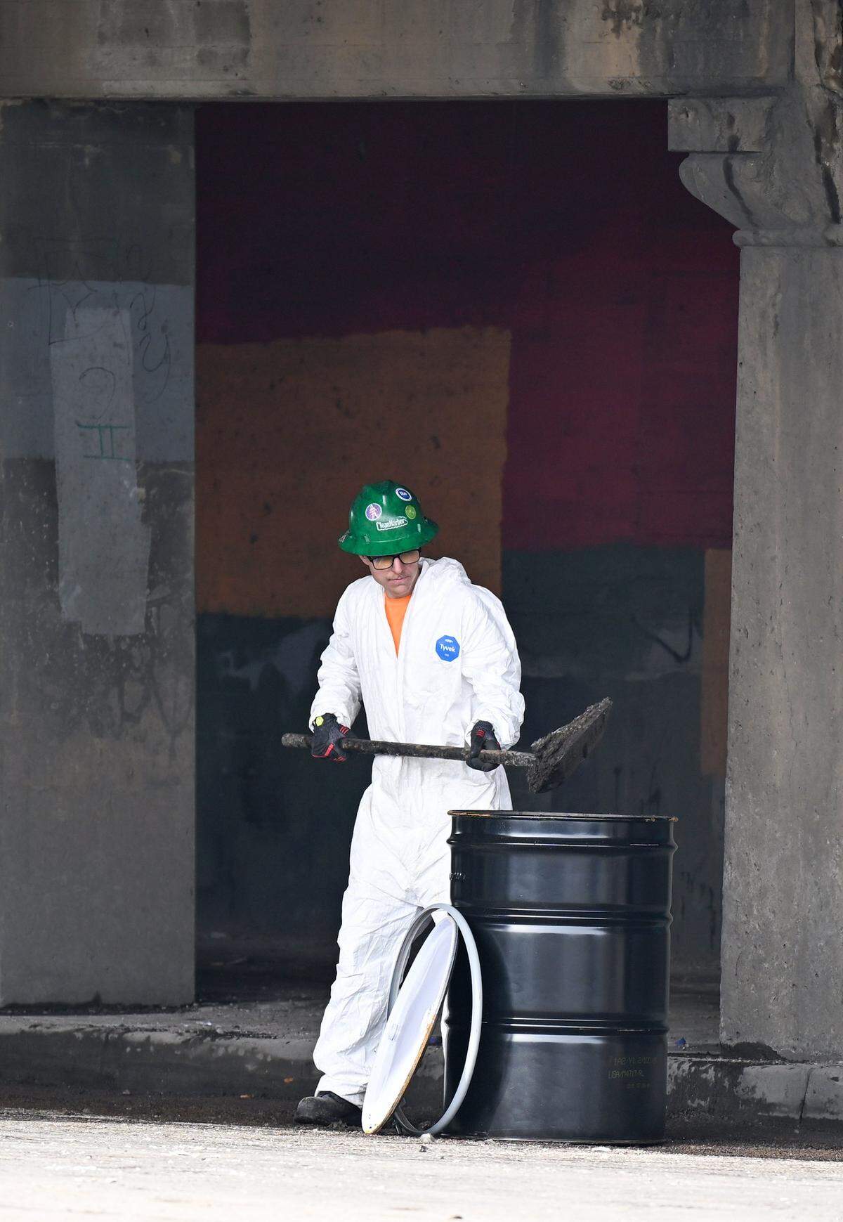 A hazmat worker cleans up after a semi struck Kansas City's notorious “truck-eating bridge” on Tuesday, Feb. 2, 2026. The low-clearance bridge on Independence Avenue is frequently struck by trucks that are too tall to fit underneath. 