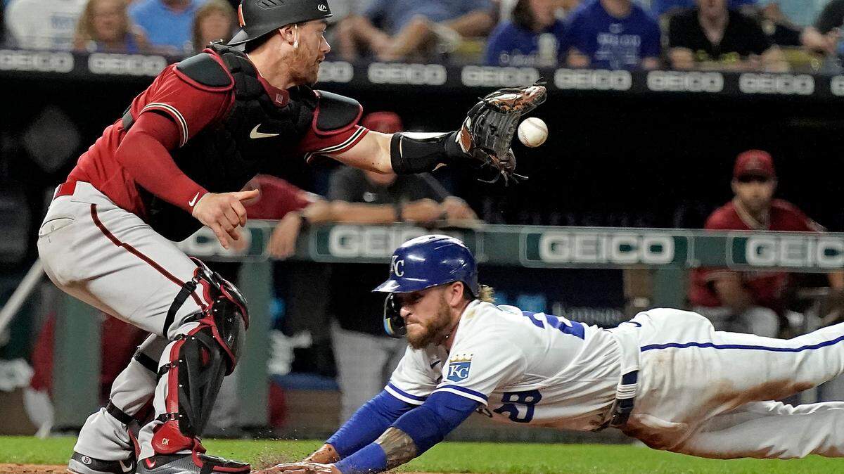 Kansas City Royals’ Kyle Isbel beats the tag by Arizona Diamondbacks catcher Carson Kelly to score on a sacrifice bunt hit by Nicky Lopez during the seventh inning of a baseball game Wednesday, Aug. 24, 2022, in Kansas City, Mo. (AP Photo/Charlie Riedel)