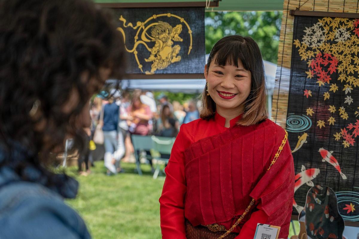 Yeon Ji helps a customer find a pair of earrings at the Saranya Hubbard booth during the AAPIconic Festival on Saturday, May 20, 2023, in Kansas City.