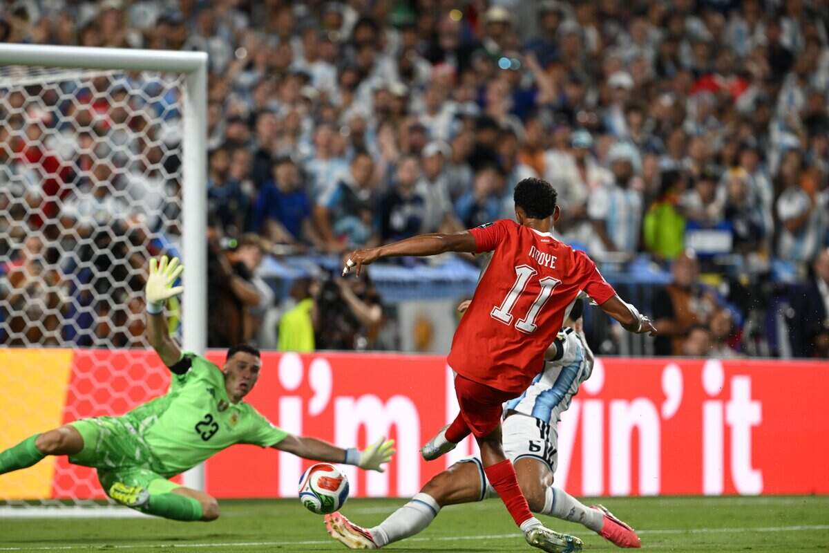 Argentina goalkeeper Emiliano Martínez (23) makes a save following Switzerland forward Dan Ndoye (11)'s attempt on goal in the Argentina vs. Switzerland 2026 World Cup Quarterfinal football match at Kansas City (Arrowhead) Stadium in Kansas City on Saturday, July 11, 2026.