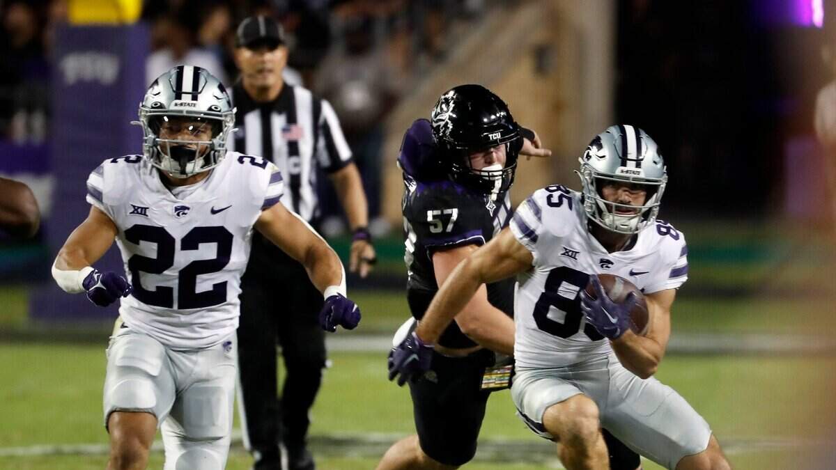Kansas State wide receiver Kade Warner (right) evades TCU linebacker Johnny Hodges during Saturday night’s game at Amon G. Carter Stadium in Fort Worth, Texas.