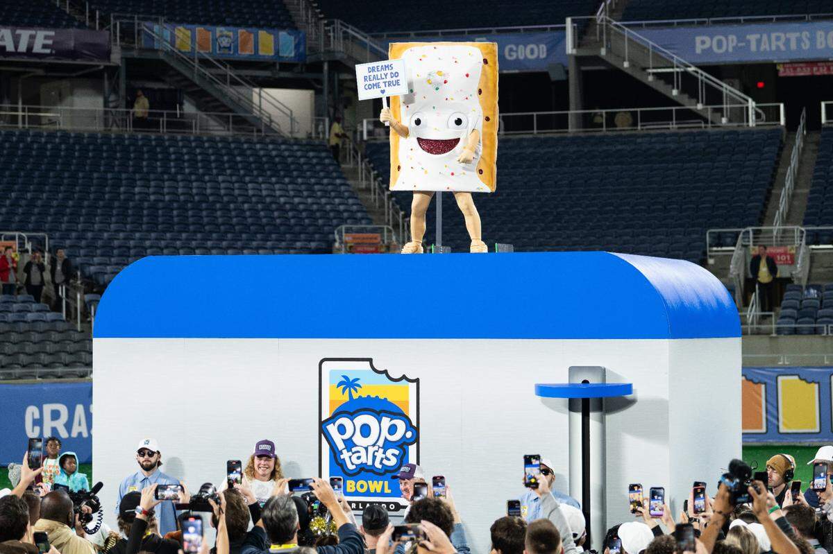 The Pop-Tarts Bowl mascot prepares to be lowered into a massive ‘toaster’ after the conclusion of the college football game between Kansas State and NC State at Camping World Stadium on Dec. 28, 2023.