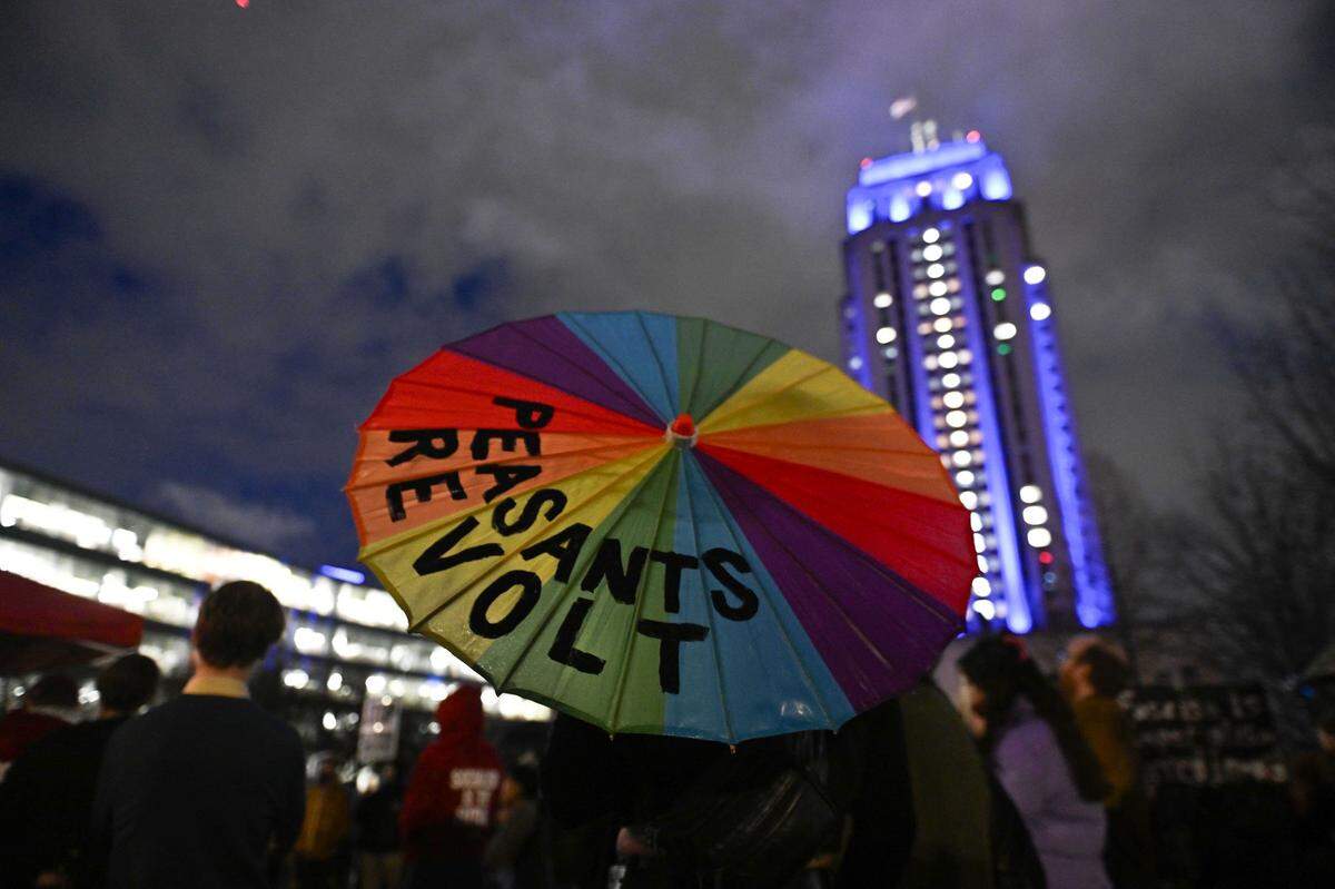 A protester holds a rainbow umbrella that says “Peasants revolt” as crowds rally against ICE outside City Hall in Kansas City on Thursday, Jan. 8. A federal agent shot and killed Renee Good, a former KC resident, in Minneapolis on Wednesday, Jan. 7.