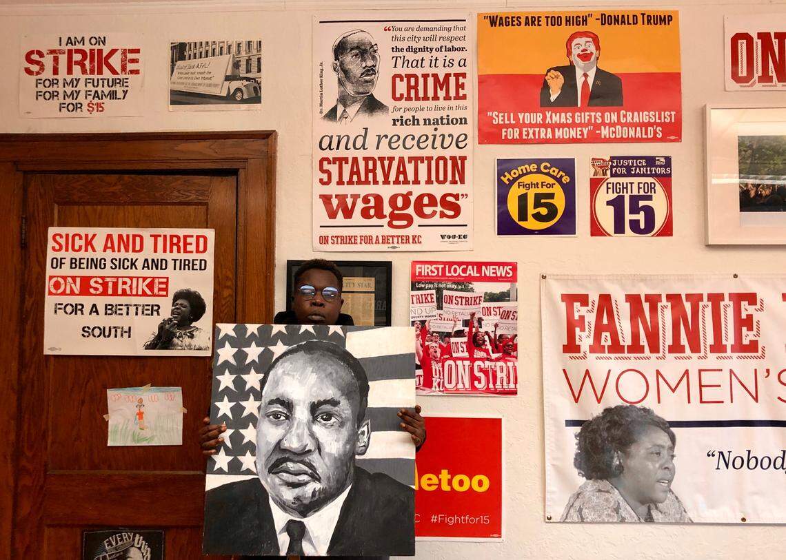 Pictures of activists fill the walls of the Stand Up KC office on Troost Avenue. Fran Marion, a leader of the group, poses there, holding a portrait of the Rev. Martin Luther King Jr.