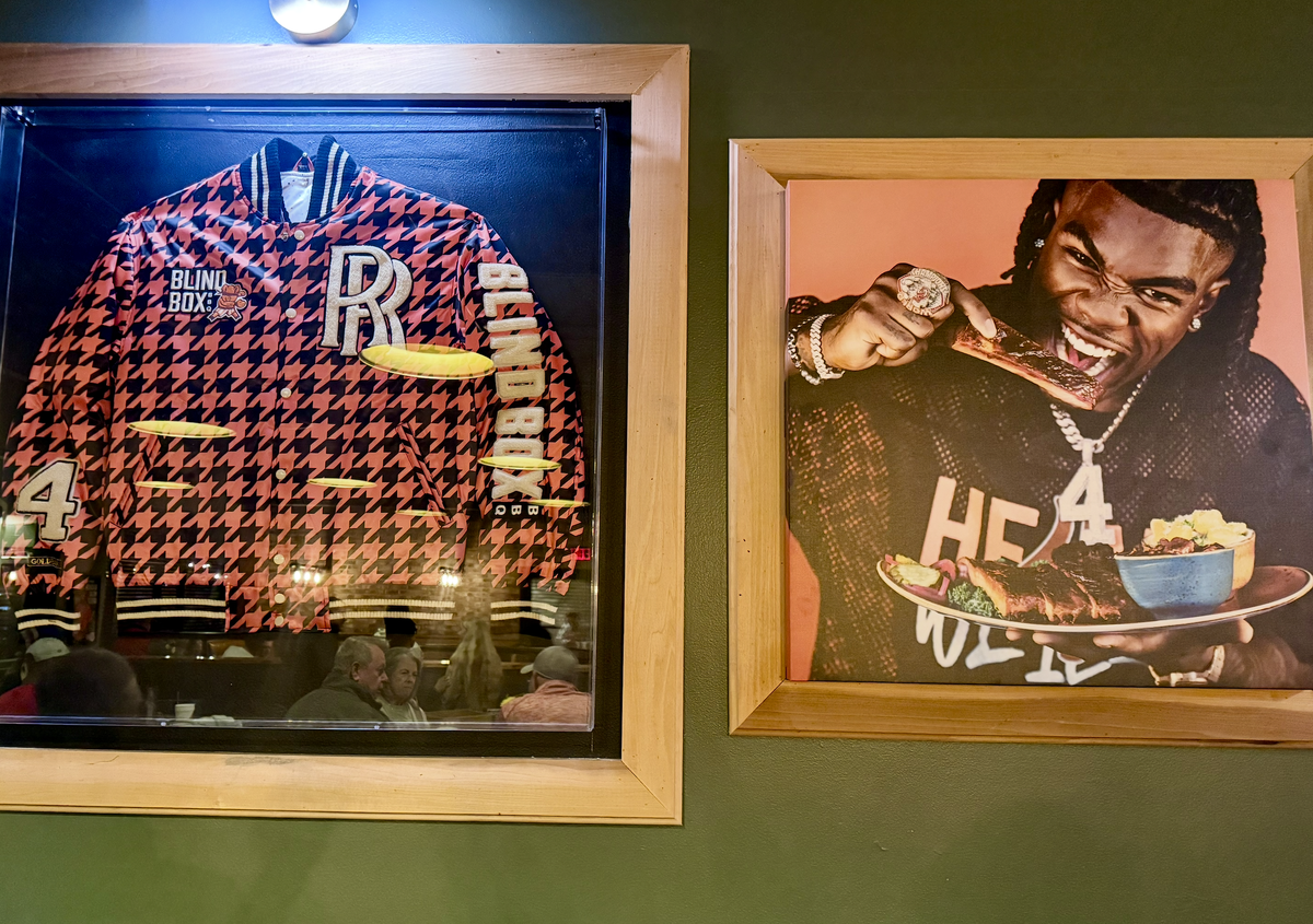 Photographs of Rashee Rice and partnership merchandise hang on the walls throughout Blind Box BBQ in Shawnee. 
