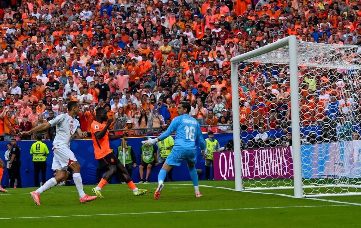 Netherlands defender Denzel Dumfries (22) makes an attempt at a goal but it is blocked by Tunisia goalkeeper Aymen Dahmen (16) in the Netherlands vs. Tunisia FIFA World Cup group-stage soccer match at Kansas City (Arrowhead) Stadium in Kansas City on Thursday, June 25, 2026.