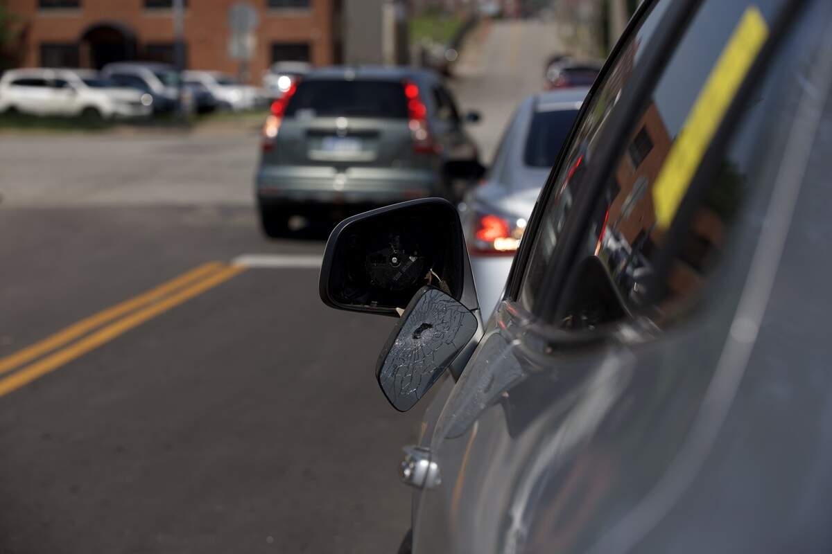 A car mirror appears to have been shot while parked at 19th and Vine streets on Saturday, June 20. Police said several people were injured and one man was killed in a shooting in the area the night before.