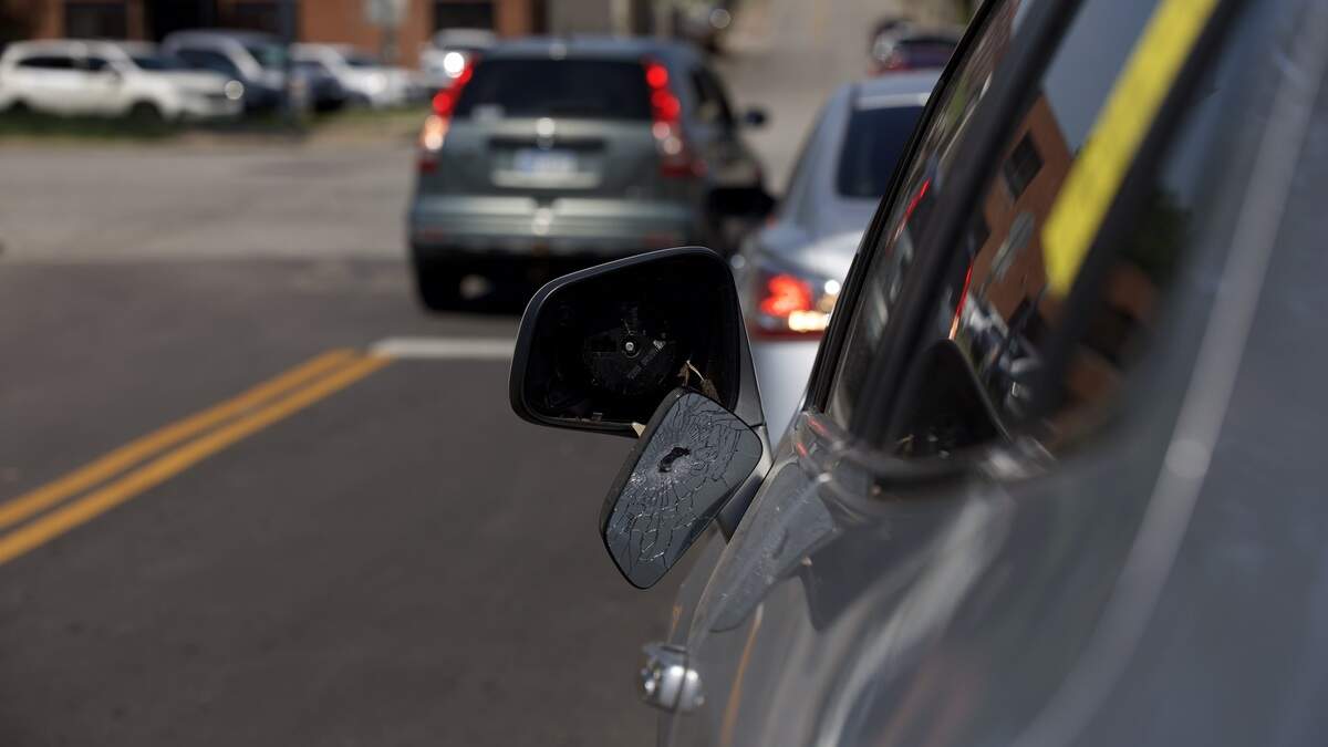 A car mirror appears to have been shot while parked at 19th and Vine streets on Saturday, June 20. Police said several people were injured and one man was killed in a shooting in the area the night before.