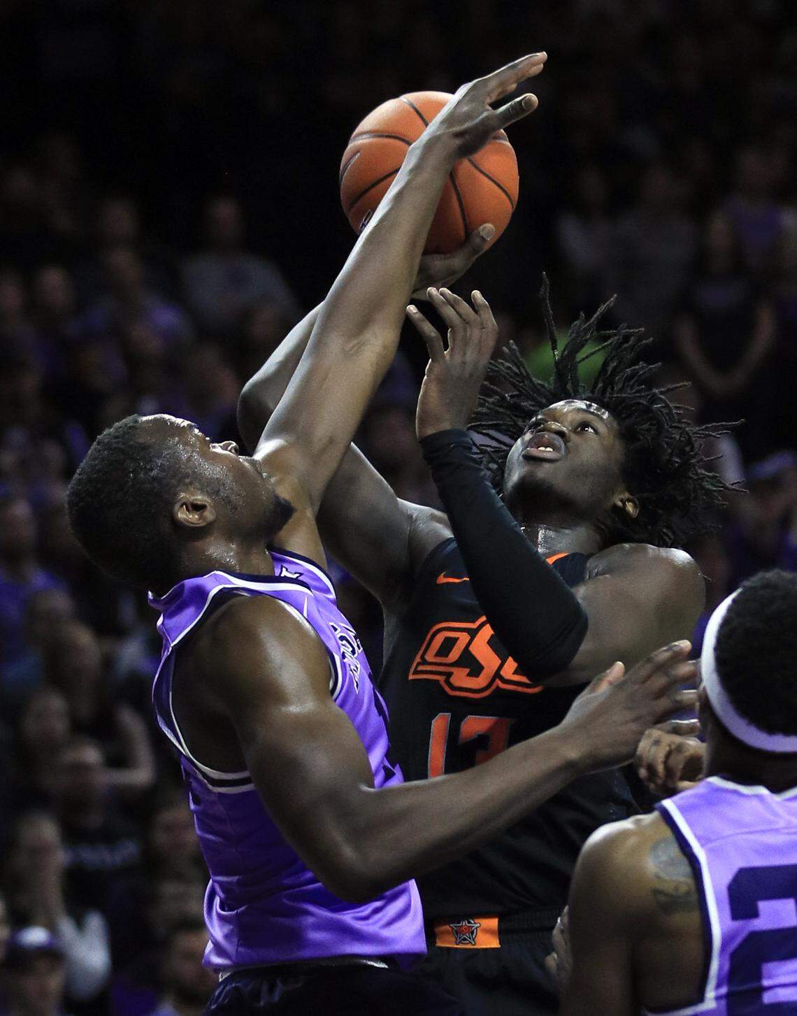 Kansas State forward Makol Mawien, left, blocks a shot by Oklahoma State guard Isaac Likekele (13) during the first half of an NCAA college basketball game in Manhattan, Kan., Saturday, Feb. 23, 2019. (AP Photo/Orlin Wagner)