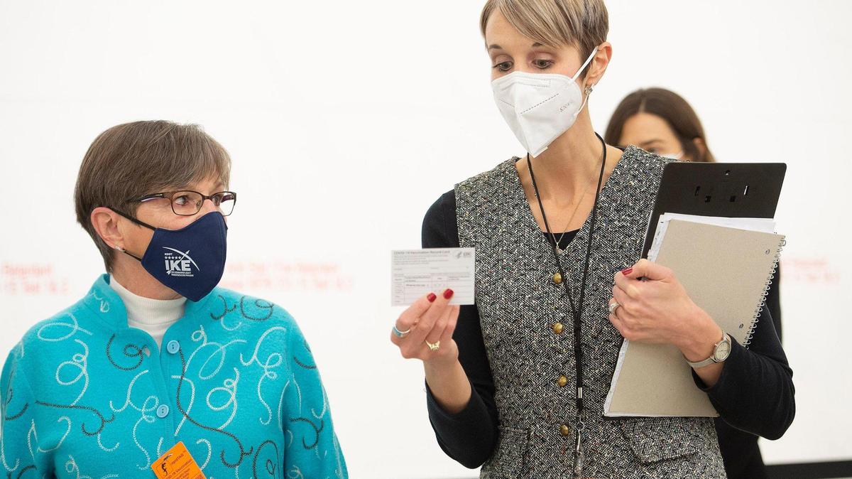 Kansas Governor Laura Kelly listened as Juliann Van Liew, director of Unified Government Public Health Department, explained a vaccination card during a tour of the COVID-19 vaccination center operated by Unified Government on Thursday, Jan. 14, 2021, in Kansas City, Kansas.