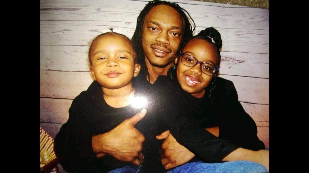 Chris Beaugard poses with his two young daughters. His family mourns the fact that the girls, now 5 and 11, will grow up without their father.