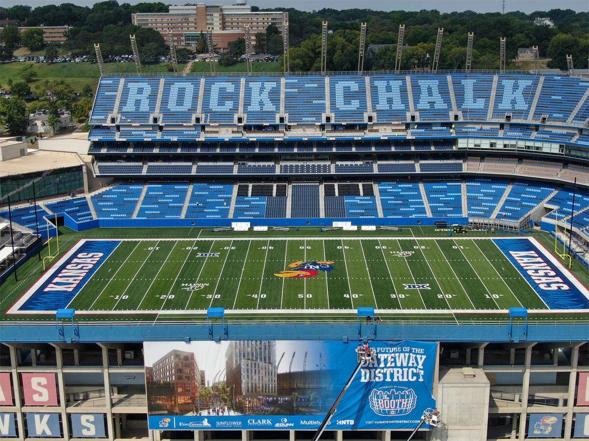 Crews hang a banner touting the future of the Gateway District as renovations at David Booth Kansas Memorial Stadium are wrapping up on Monday, August 18, 2025, in Lawrence. The Kansas Jayhawks host Fresno State on Saturday, August. 23, 2025, in the home opener at the renovated facility at the University of Kansas in Lawrence, Kansas.