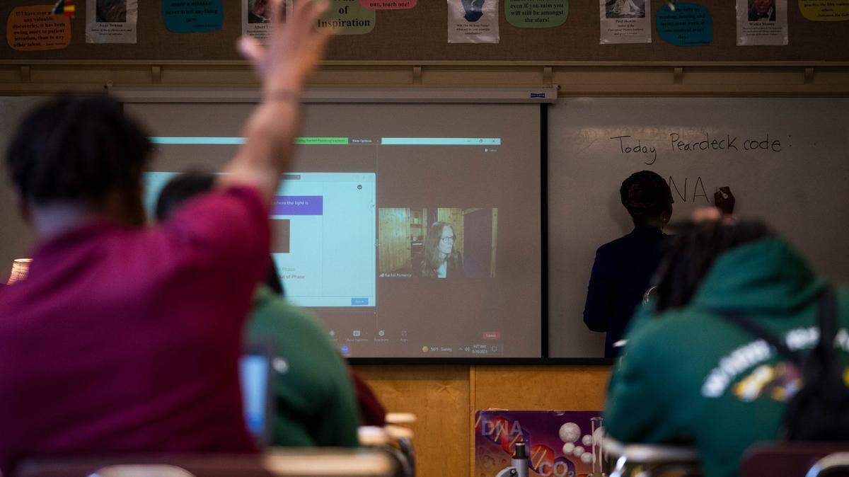 Thurgood Marshall Academy Public Charter High School Science students watch their instructor Rachel Pomeroy, on screen, during class on May 10, 2023 as the instructor taught the class virtually broadcast virtually through the Owl Labs Meeting Owl 3 camera.