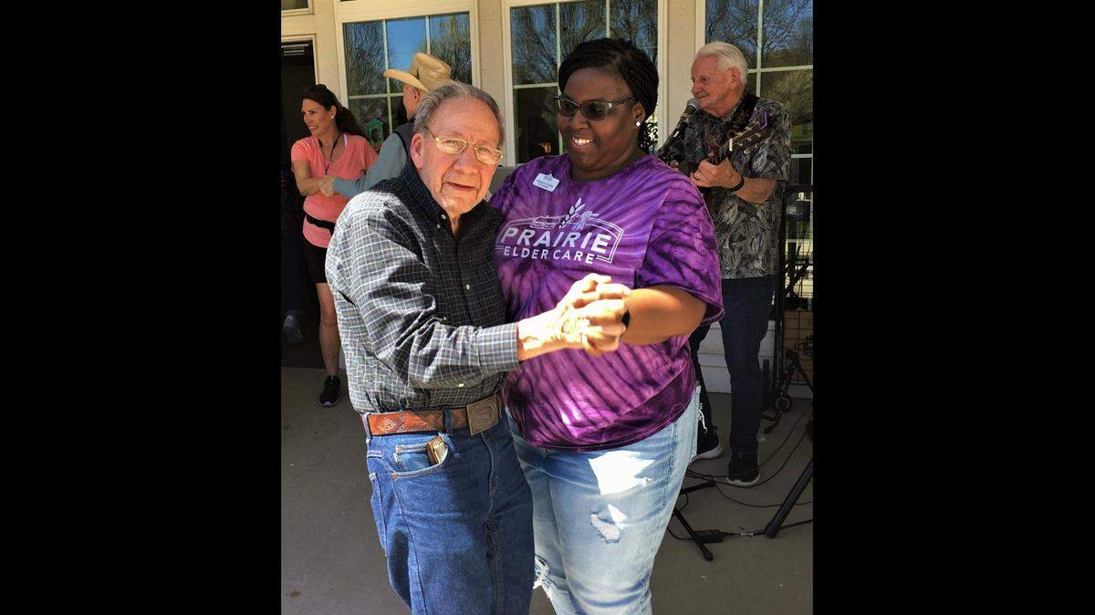 Ray Hodge enjoys a dance with Candace Johnson while Mike Ashley plays his guitar and sings. Johnson is the office manager for Prairie Elder Care.