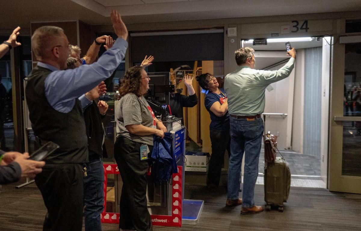 Southwest Airlines employees send off the final passenger to board the final flight to take off from Kansas City International Airport’s old terminals on Monday, Feb. 27, 2023, in Kansas City.