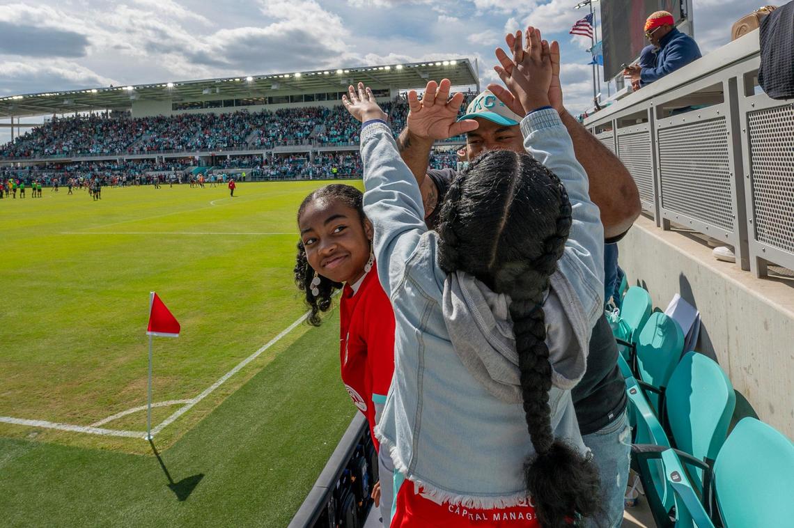 Eleven-year-old Jordyn Johnson watches as her sister and father exchange high fives after the Kansas City Current defeated the Portland Thorns FC 5-4 in the inaugural game at CPKC Stadium on Saturday, March 16, 2024, in Kansas City.