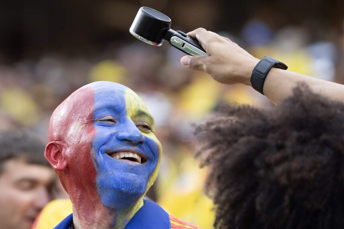 A fan cheering on Colombia gets cooled by a friends portable fan before Colombia took on Ghana at a FIFA World Cup knockout stage soccer match at Kansas City (Arrowhead) Stadium in Kansas City on Friday, July 3, 2026.