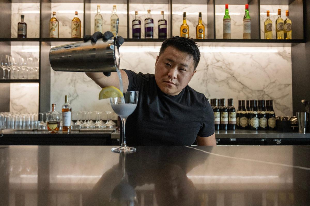 Belly Vang, owner of Entity Lounge, serves cocktails like the Water Lily, which has gin, dry curacao, creme de violette and is topped with a slice of lemon.