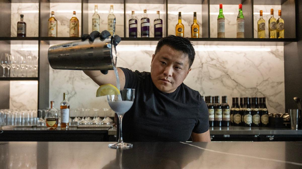 Belly Vang, owner of Entity Lounge, serves cocktails like the Water Lily, which has gin, dry curacao, creme de violette and is topped with a slice of lemon.