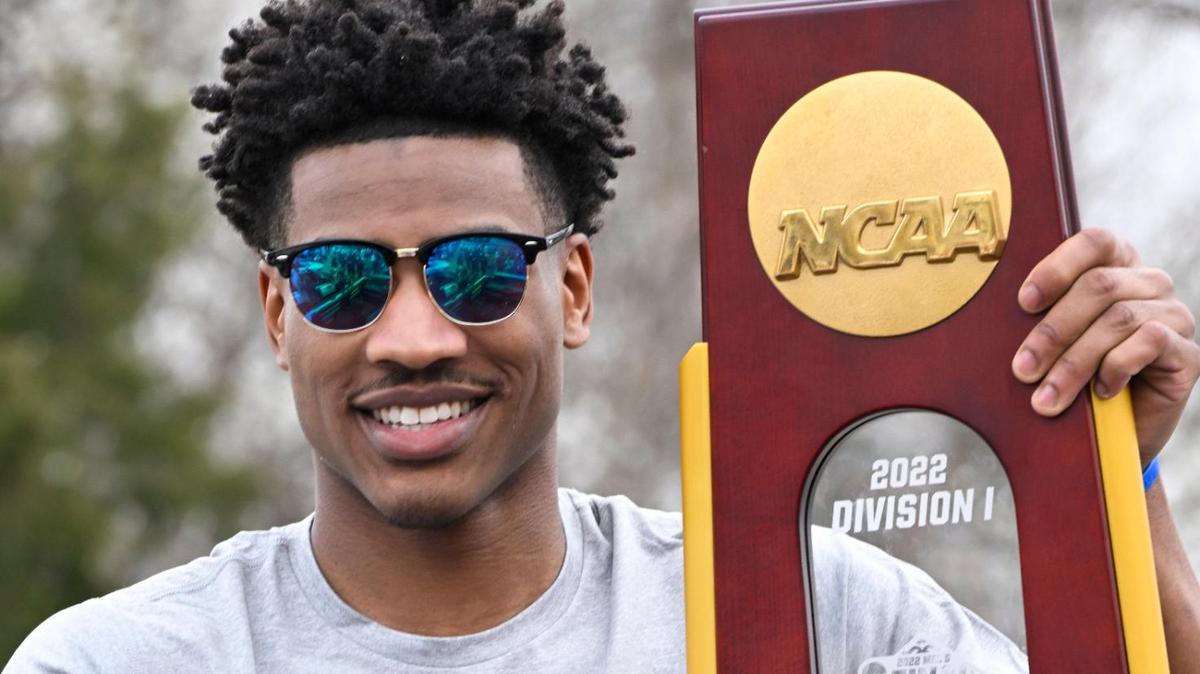 Kansas guard Ochai Agbaji poses with the NCAA Division 1 Championship trophy before their victory parade in Lawrence Sunday afternooon.