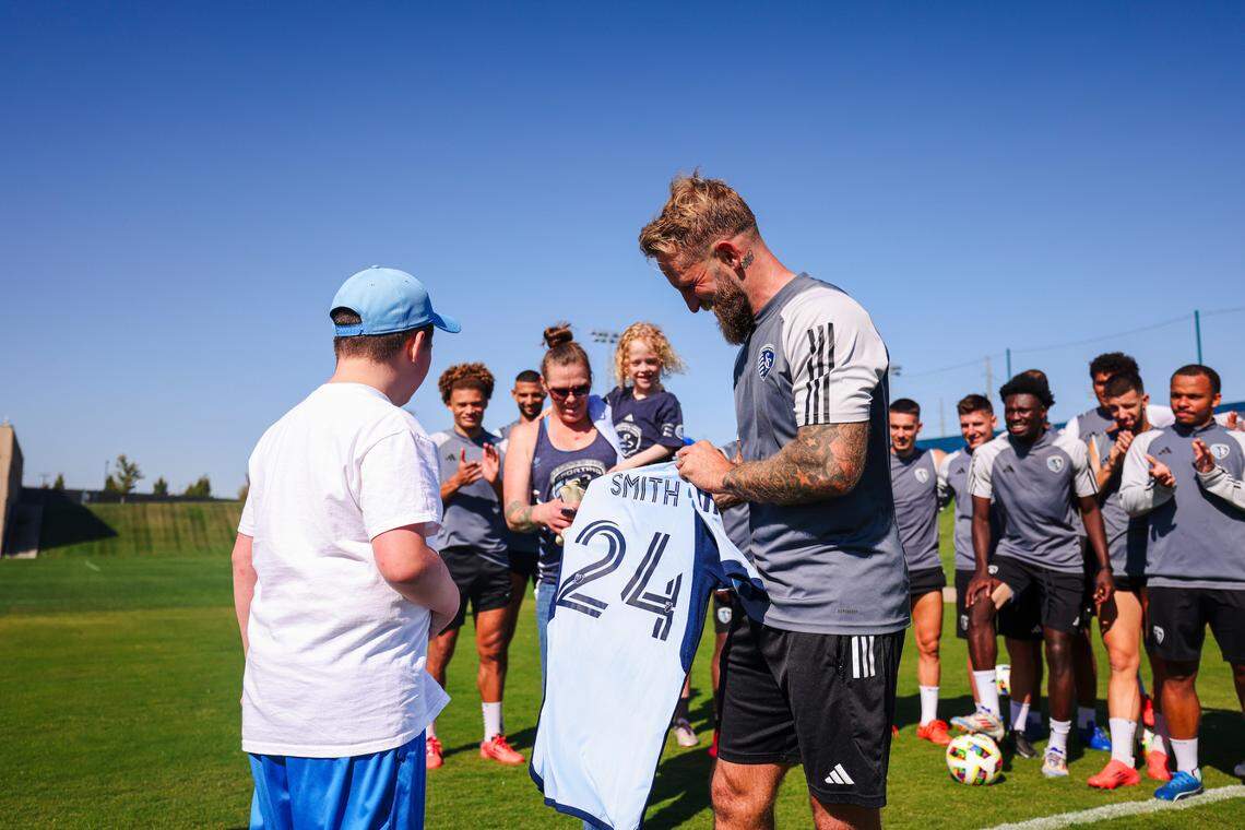 Sporting Kansas City captain Johnny Russell presents 11-year-old Miles Smith with a jersey at midweek training.
