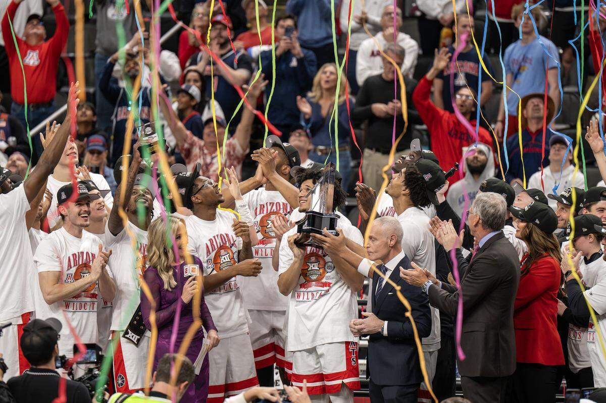 Confetti falls as the Arizona Wildcats players celebrate after defeating the Houston Cougars 79-74 in the Big 12 Men's Basketball Tournament Championship game at T-Mobile Center on Saturday, March 14, 2026, in Kansas City.