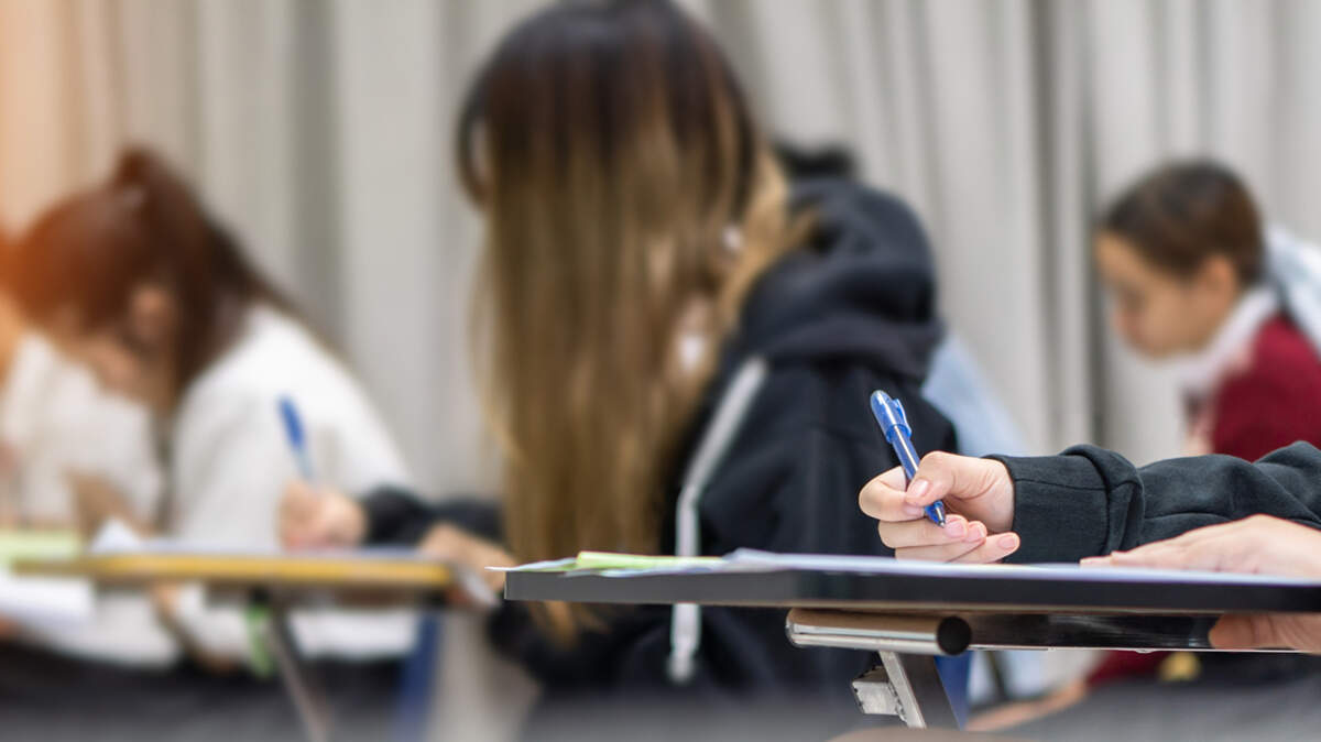 Exam at school with student taking educational admission test in class, thinking hard, writing answer in university classroom, education and world literacy day 