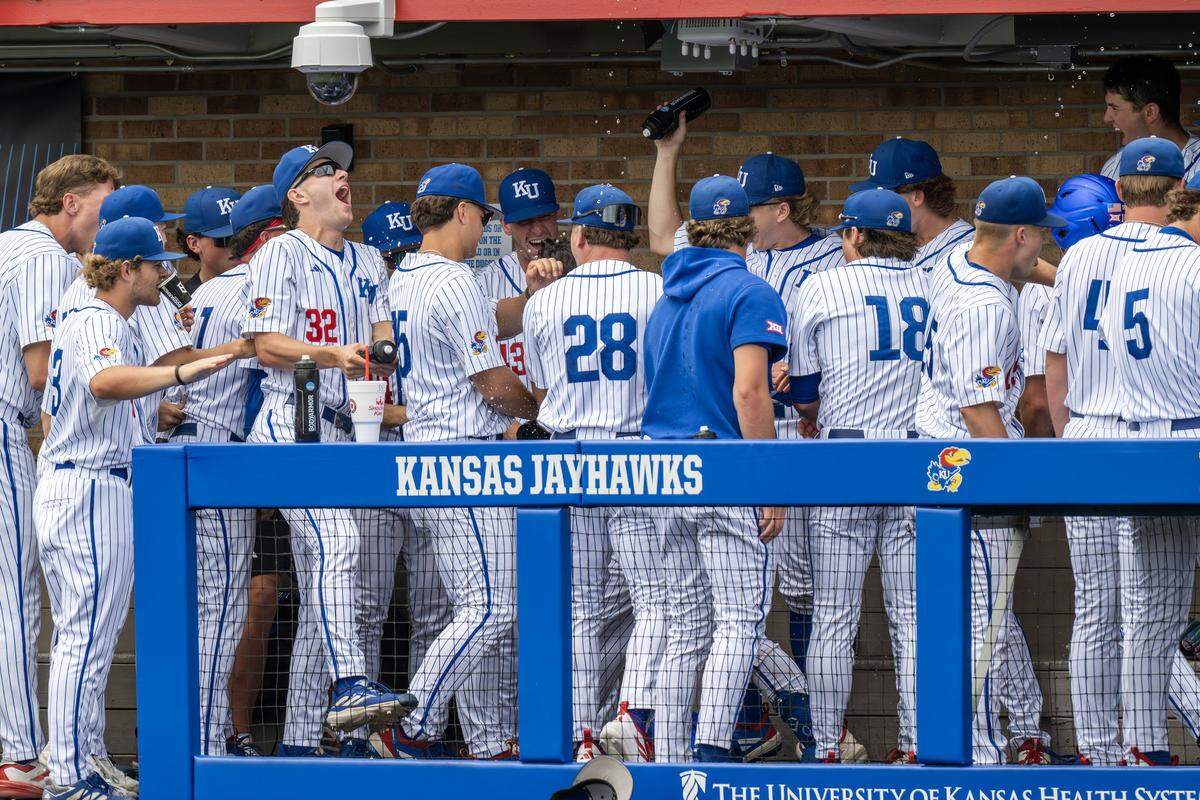 Kansas Jayhawks teammates celebrate with catcher Augusto Mungarrieta (21) in the dugout after he hit a home run against the Northeastern Huskies in the third inning of an NCAA baseball tournament game at Hoglund Ballpark on Friday, May 29, 2026, in Lawrence.