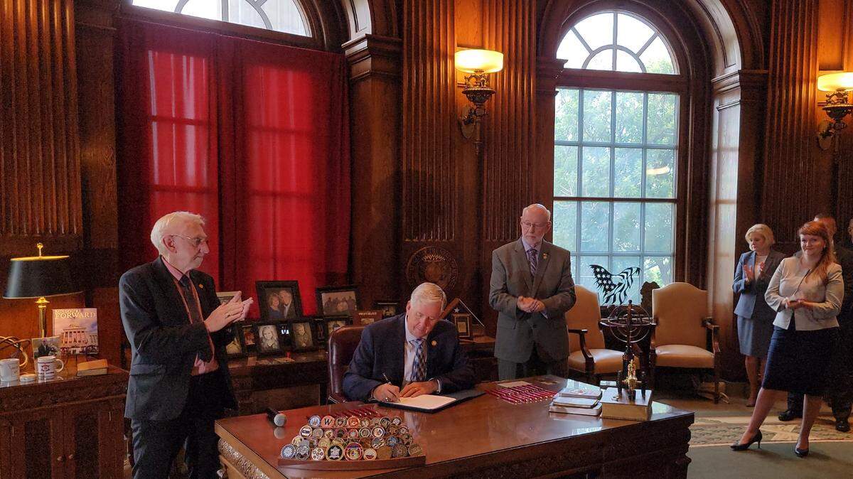 Missouri Gov. Mike Parson signed legislation in 2021 giving the state oversight of unlicensed Christian boarding schools. Looking on were Rep. Rudy Veit, left, Sen. Bill White, right, and Rep. Keri Ingle, to White’s right.