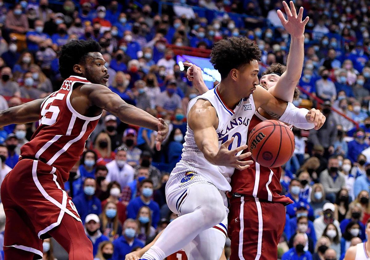 KU’s Jalen Wilson looks for an open teammate while being guarded by OU’s Elijah Harkless, left, and Tanner Groves during the first half of Saturday’s Big 12 Conference game at Allen Fieldhouse.