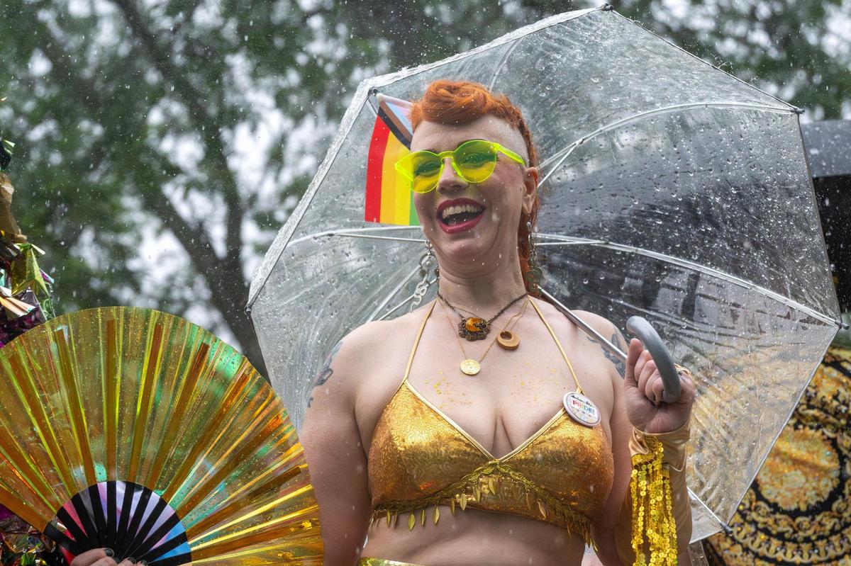 A parade participant cheers as heavy rain falls during the KC Pride Parade.
