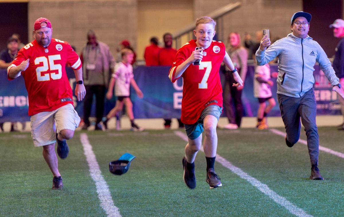 Cameron St. Amand, left, of Greenwood, Mo., runs a 40-yard dash with his son, Cale, 14, at the NFL’s Super Bowl Experience on Thursday, Feb. 9, 2023, in Phoenix.