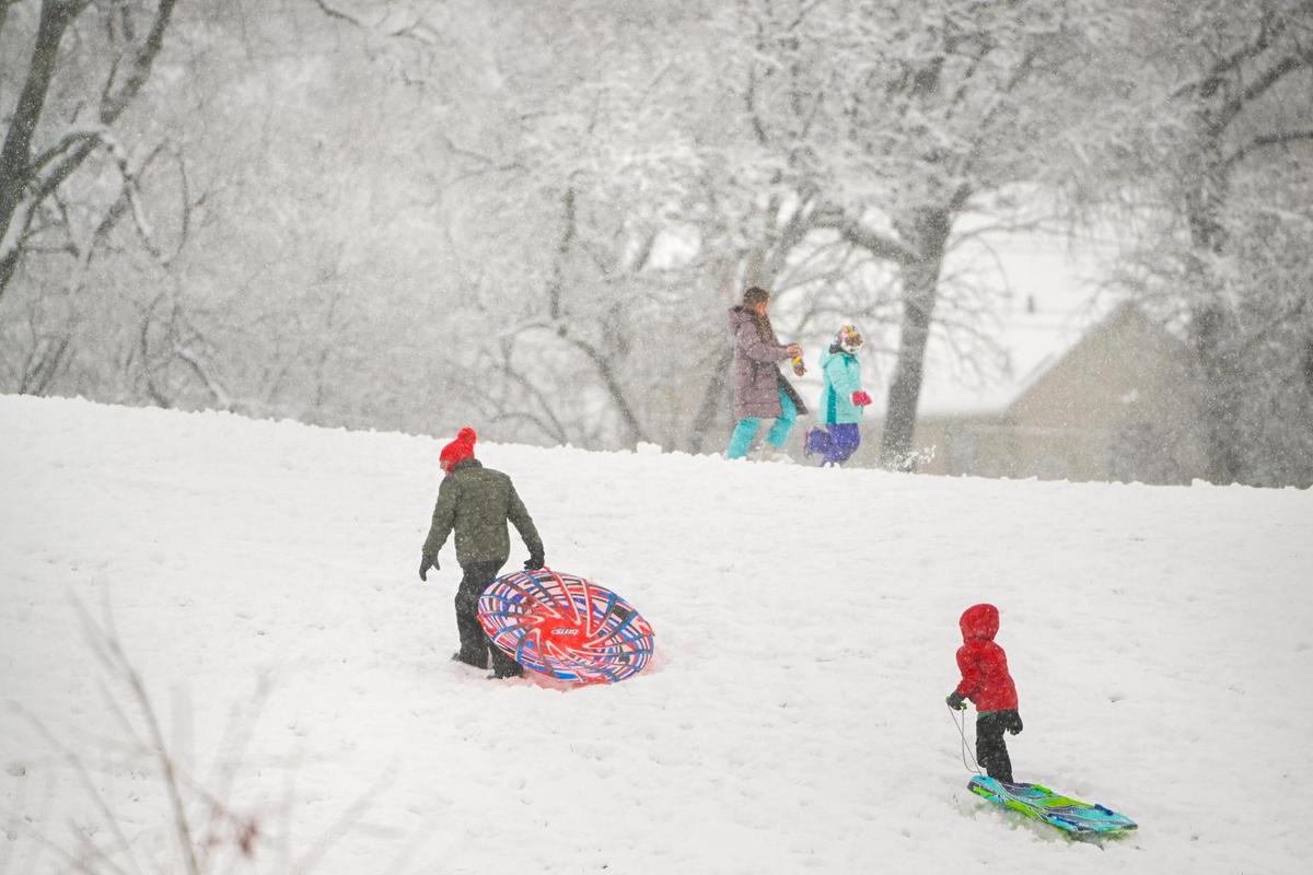 Sledders walked up a hill at Meadowbrook Park on Tuesday, Jan. 9, 2024, which was covered in snow after a winter storm dropped several inches of snow in the metro area including in Prairie Village.