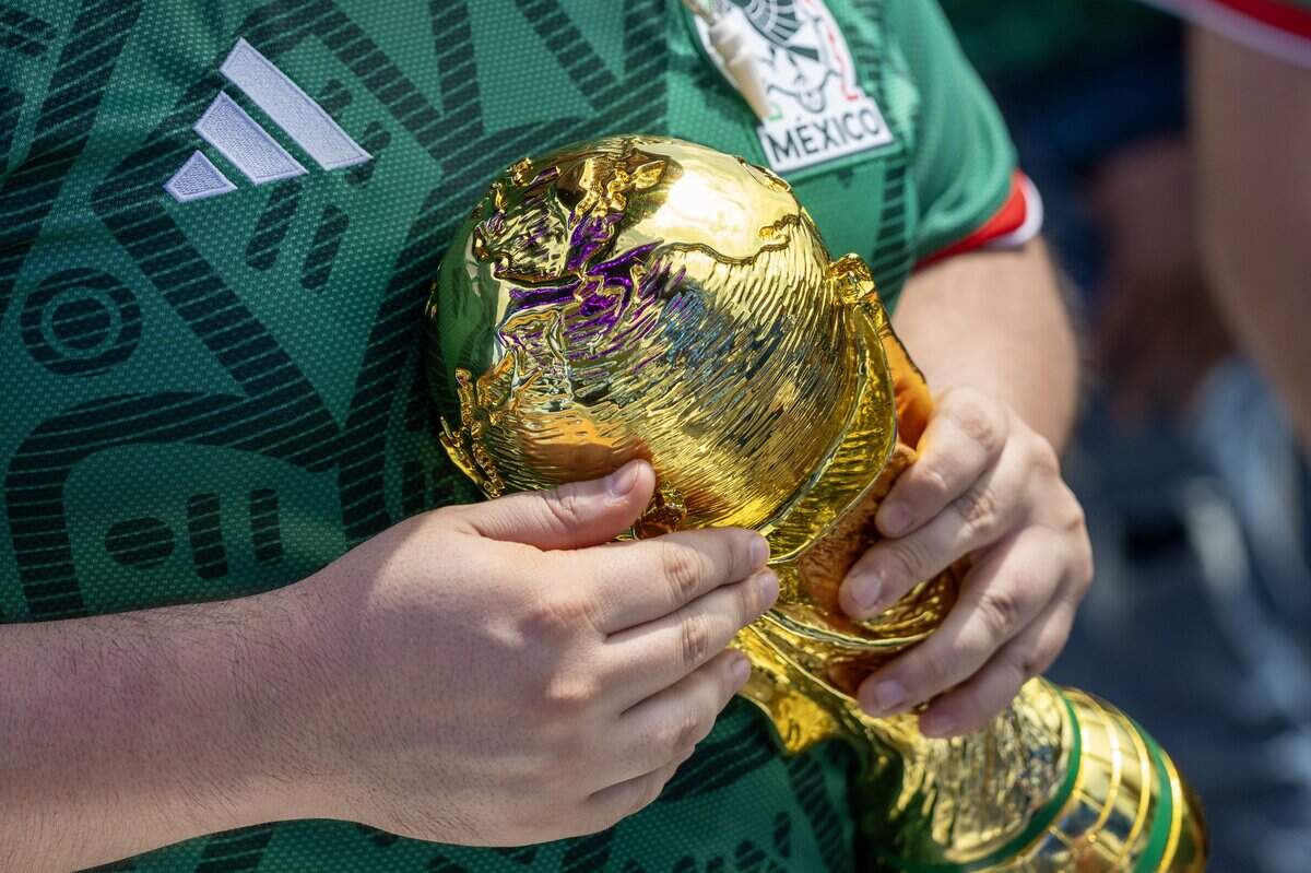 Armando Moreno holds a replica of the FIFA World Cup trophy while attending the FIFA Fan Festival on Thursday, June 11, 2026, in Kansas City.