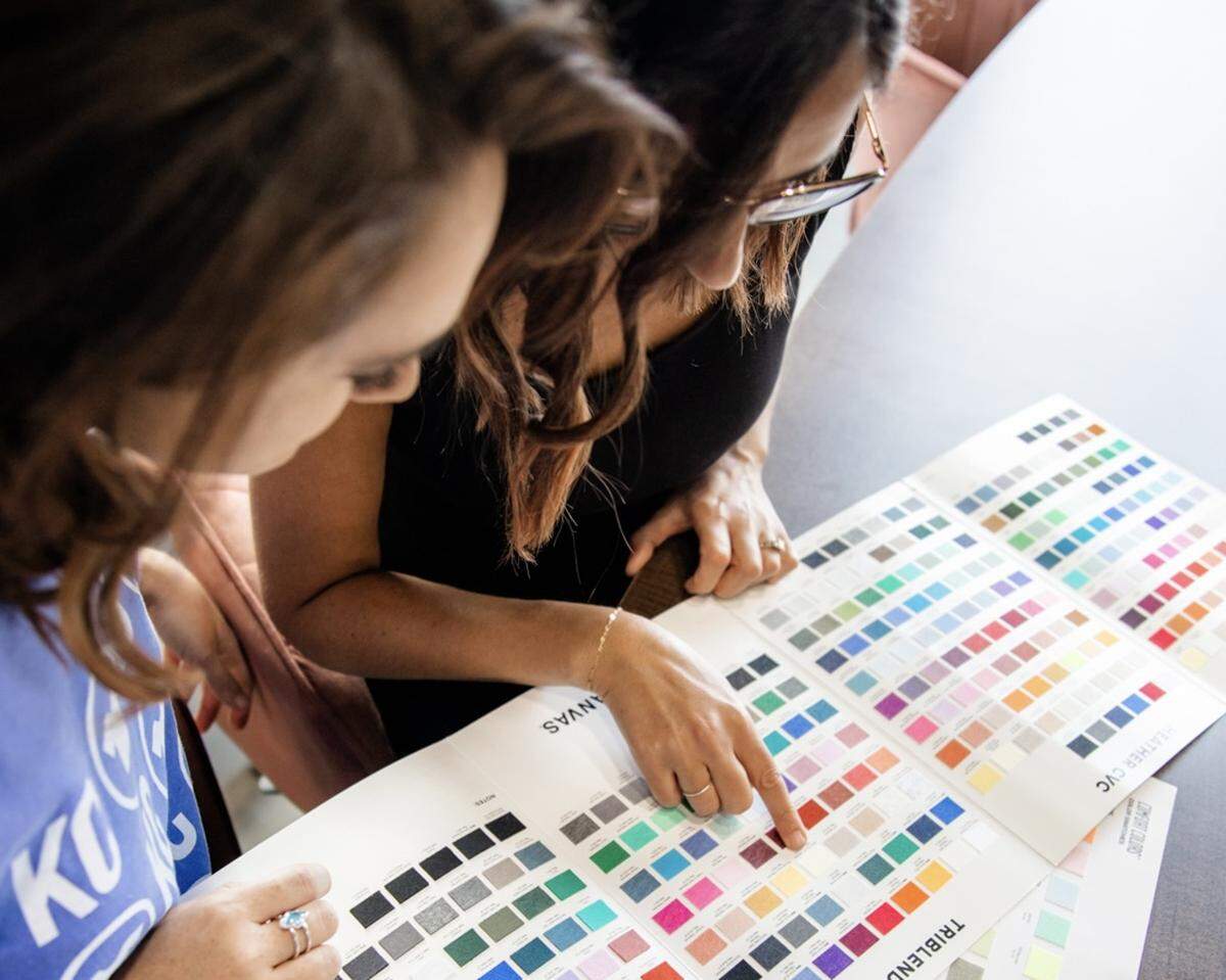 Sarah Lee (left), production manager, and Gina Seibel, owner operator, review garment color swatches.