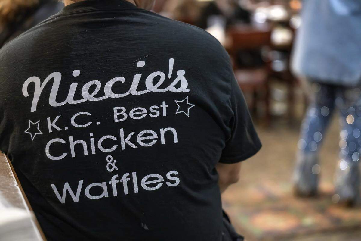 A patron wears a “Niecie's” shirts as Denise “Ms. Niecie” Ward sings during “Dinner & A Show” on Friday, Feb. 6, 2026, at Niecie's Restaurant in Kansas City. Ward performs on the First Friday of every month at her soul food restaurant.