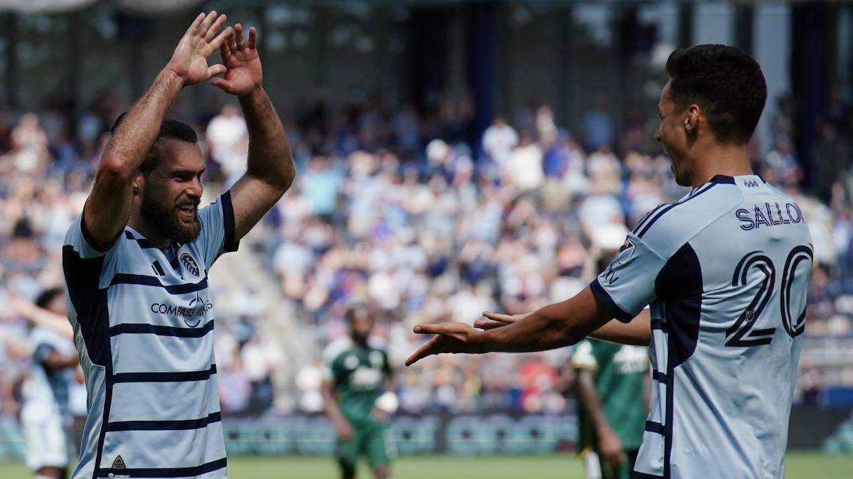 Sporting Kansas City forward Daniel Salloi, right, celebrates with midfielder Graham Zusi after scoring a goal against the Portland Timbers on Sunday at Children’s Mercy Park.