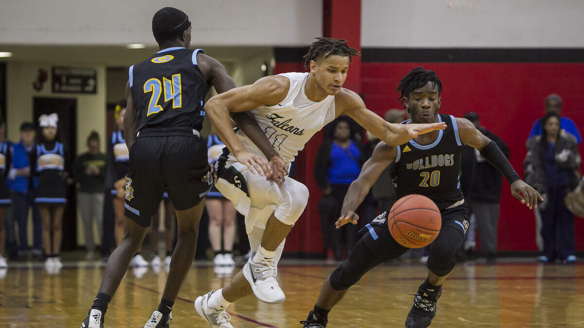 Staley forward Byron Alexander attempts to split Grandview defenders Reggie King (No. 24) and Camden Smith (20) during Monday night’s game at William Jewell College, site of the annual Holiday Classic boys basketball tournament.