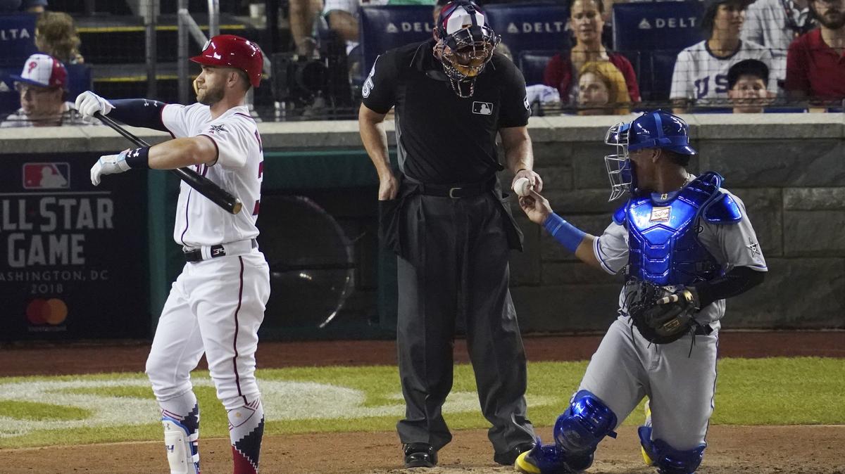 Kansas City Royals catcher Salvador Perez hands the ball to the umpire after the Nationals' Bryce Harper strikes out in the fourth inning of Tuesday's All-Star Game in Washington.