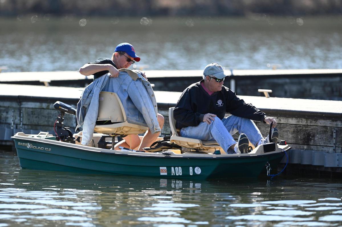 Dave Dahl, left, of Shawnee, removed his coat after he and Ken Conrad, also of Shawnee, boarded a 10-foot boat to go trout fishing in the unseasonably warm weather Wednesday, March 2, 2022, at the lake at Shawnee Mission Park in Shawnee. “This lake was all iced up on Saturday and you couldn’t fish if you wanted to,” said Dahl.