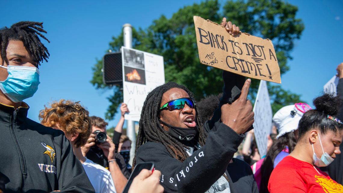 A protester points to his sign’s message at the Black Lives Matter protest at the Country Club Plaza on Sunday, May 31, 2020. The protest was the third one in Kansas City this weekend following the death of George Floyd.