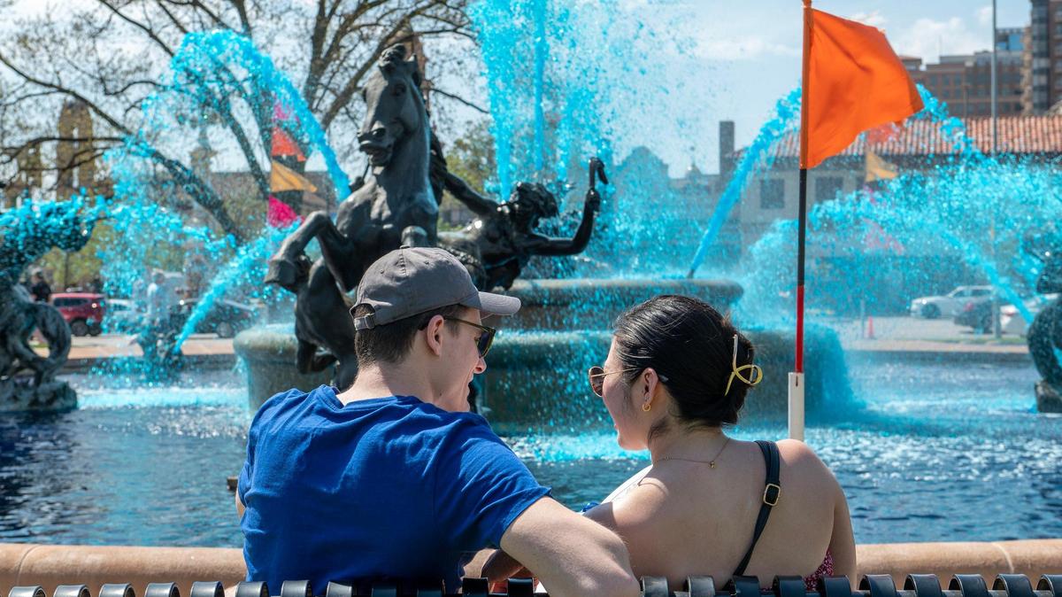 Visitors attend the opening celebration of Fountain Day at Mill Creek Park on Friday, April 14, 2023, in Kansas City. The Mill Creek fountain was dyed blue to celebrate the Kansas City Royals. One of the city’s publicly owned fountains will be dyed blue each month through September. 
