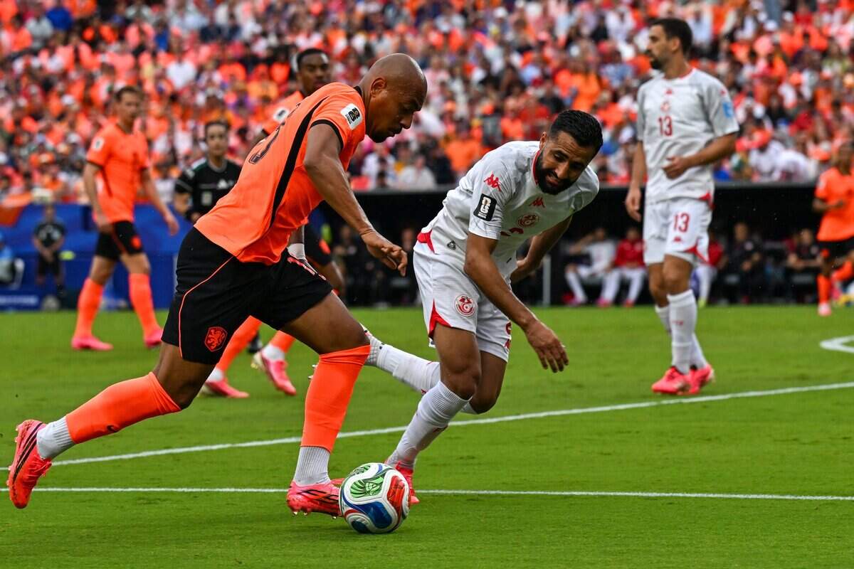 Netherlands is on the attack as Tunisia midfielder Rani Khedira (13) attempts to defend in the Netherlands vs. Tunisia FIFA World Cup group-stage soccer match at Kansas City (Arrowhead) Stadium in Kansas City on Thursday, June 25, 2026.