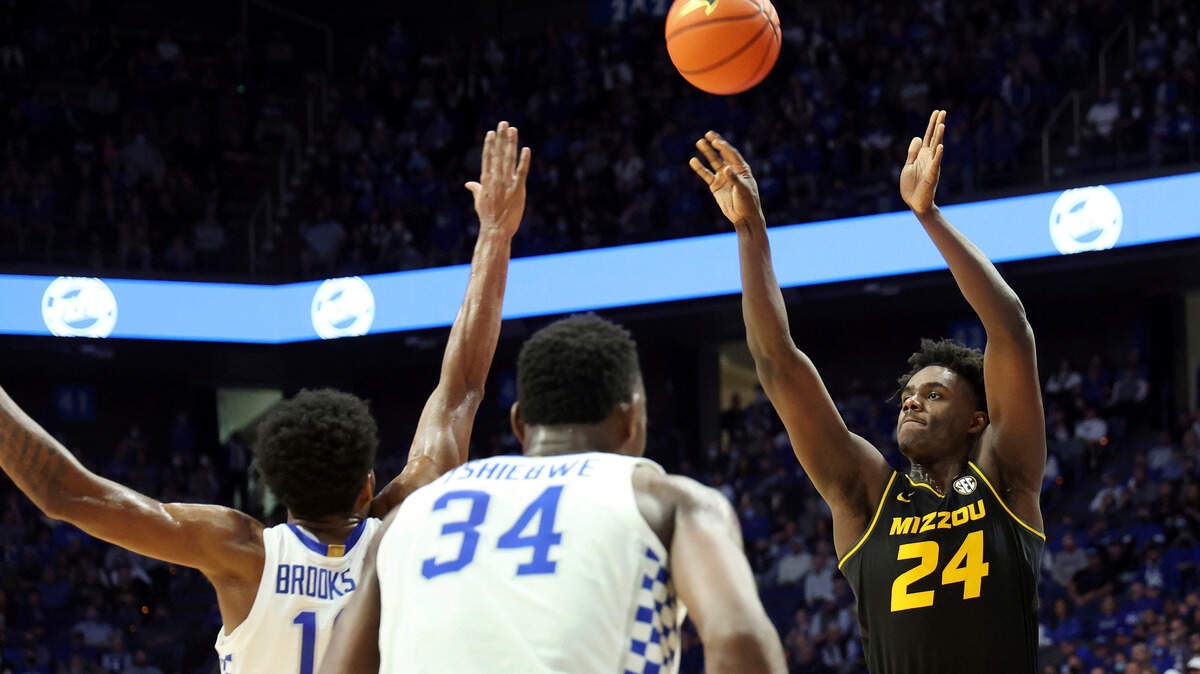 Missouri’s Kobe Brown (24) shoots over the defense of Kentucky’s Keion Brooks Jr., left, and Oscar Tshiebwe (34) during the second half of an NCAA college basketball game in Lexington, Ky., Wednesday, Dec. 29, 2021. Kentucky won 83-56. (AP Photo/James Crisp)
